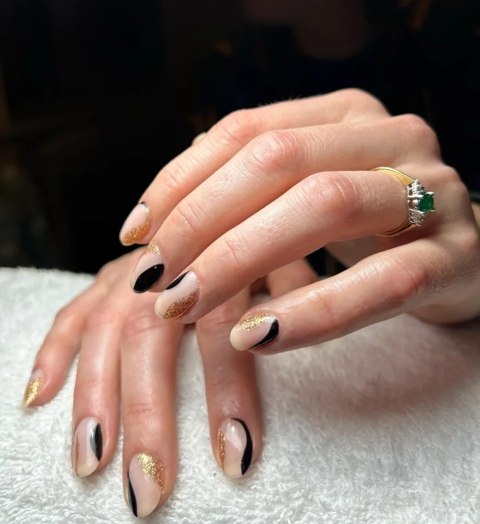 Nude-Nails-with-Black-Swirls-Gold-Glitter-Accents.webp

